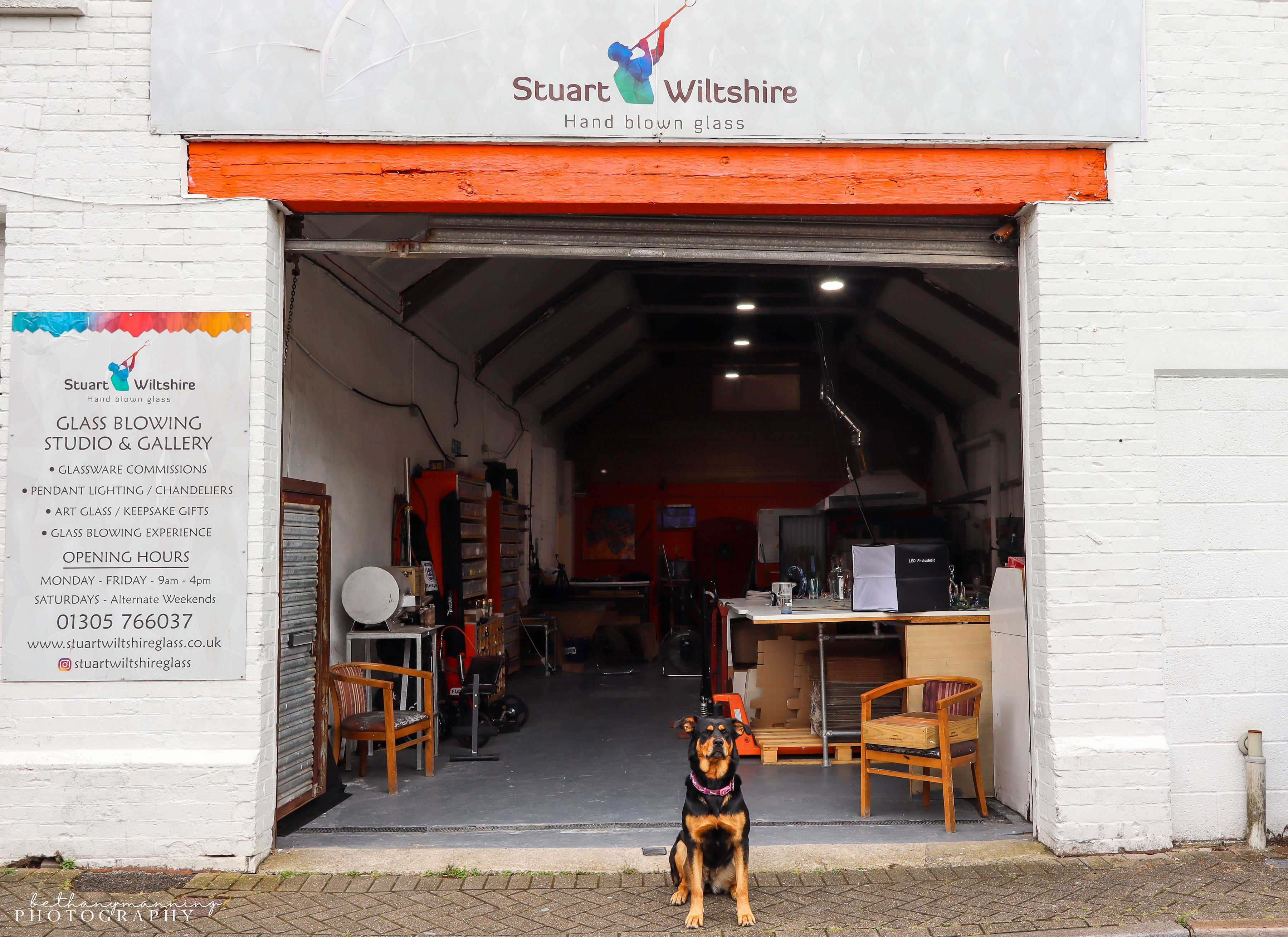 Stuart Wiltshire glass blowing studio with a dog standing in front of the entrance.
