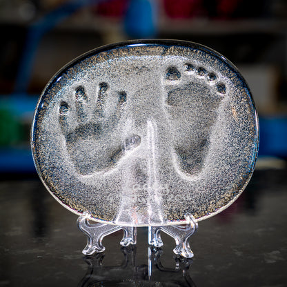New born baby hand and foot print set into glass.